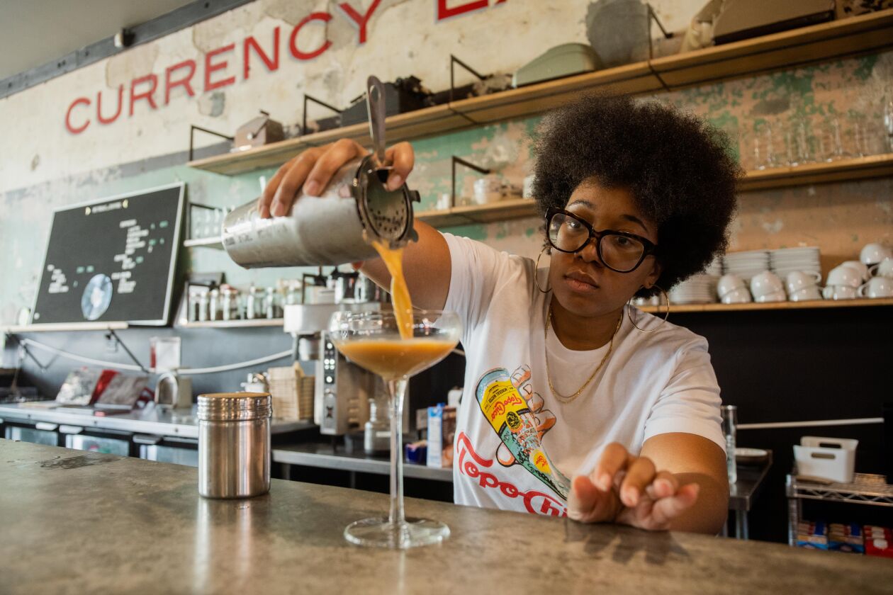 Amanda Harth, co-founder of Monday Coffee Company, prepares a drink at Retreat at Currency Exchange Café, located at 305 E. Garfield Blvd.